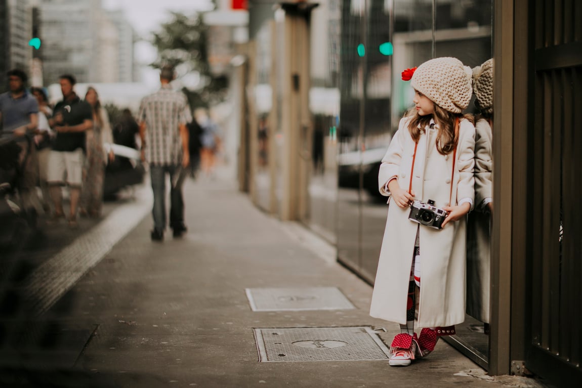 Woman in White Coat and White Knit Cap Standing on Sidewalk